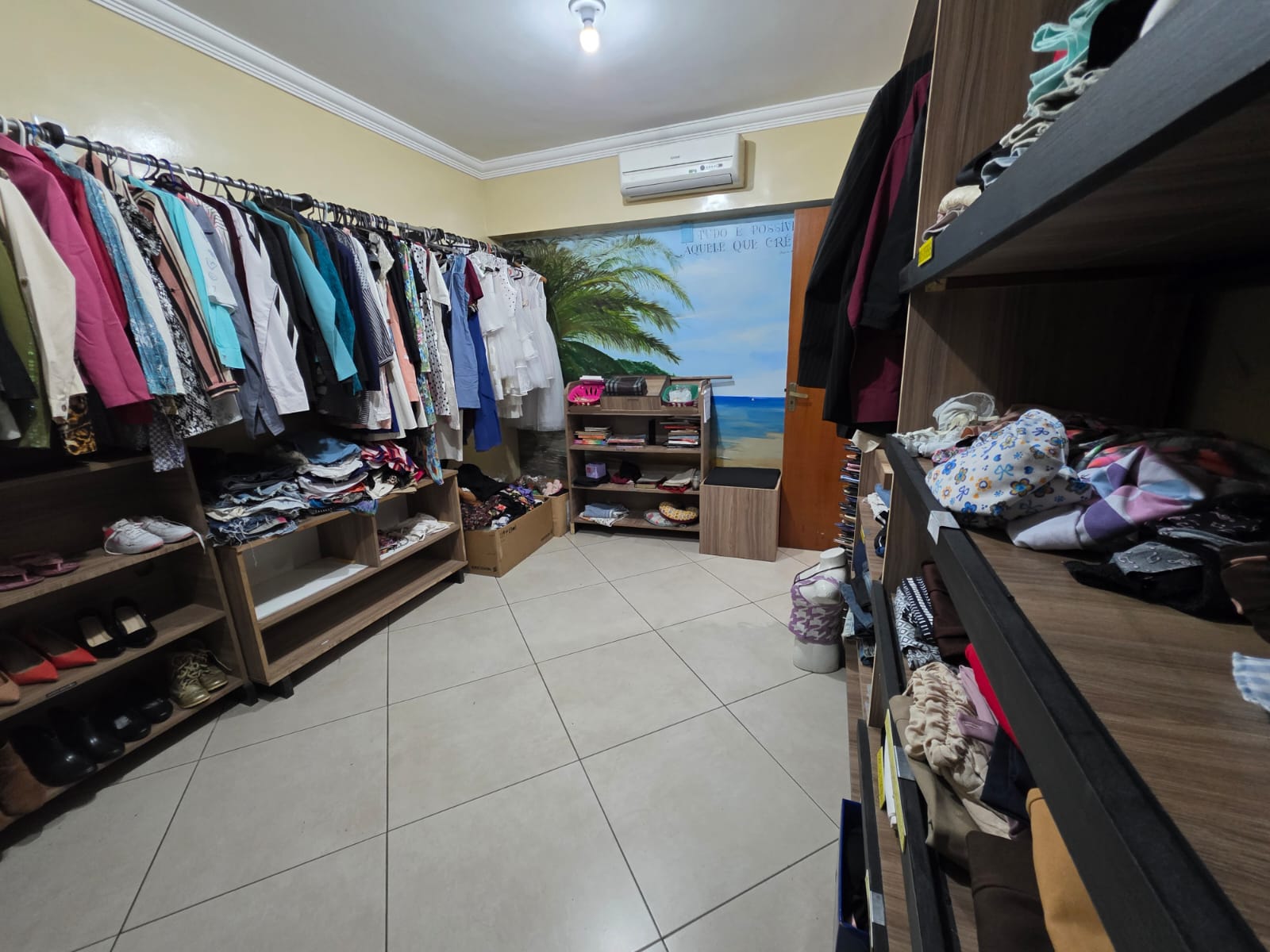 Detalhe da arara central de roupas femininas